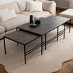 Minimalist Anton Coffee Table set in Grafite Dekton with black metal frame by by Crea. Three nesting tables arranged in a Scandinavian-style living room with a cream rug and sectional sofa, showcasing sustainable handmade design.