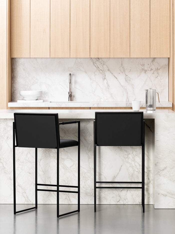 Bar Stool Bruno – Black – Jade Black Leather at a modern kitchen island with marble countertop.
