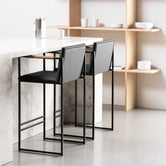 Modern Bar Stool Bruno in black and jade black leather set at a stylish kitchen island.