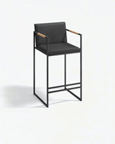 Bar Stool Bruno – Black – Jade Black Leather featuring sleek design and wooden armrests.