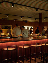 Guests gathered around the bar at Norrbottens Destilleri, with Ebba bar stools from by Crea in the foreground.
