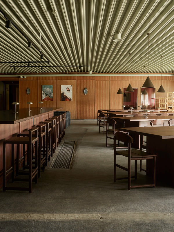 Wide interior view of Norrbottens Destilleri with Karin chairs and Ebba bar stools from by Crea arranged around the bar and tables.