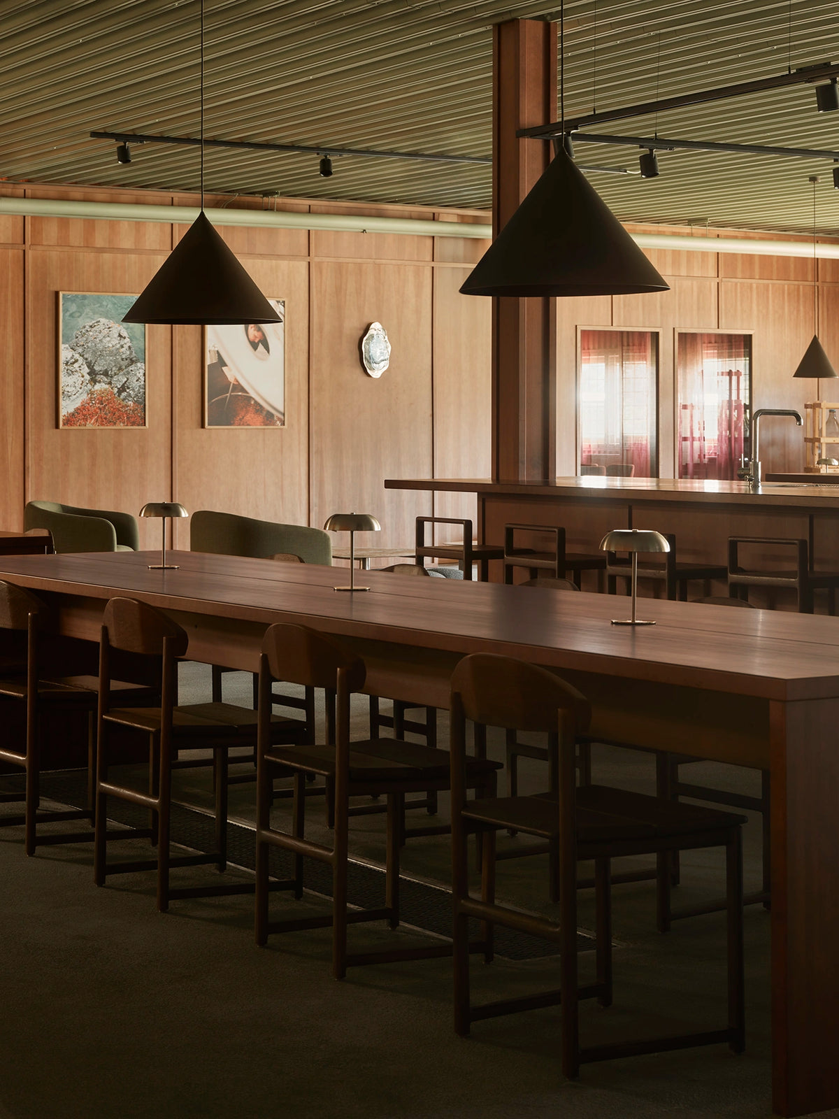 Dark wood Karin chairs and Ebba bar stools from by Crea arranged around the tables and bar at Norrbottens Destilleri.