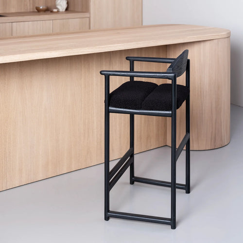 Carl bar stool in black oak with black bouclé upholstery, ideal for minimalist island seating in modern interiors.