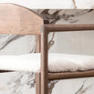 Dark oak bar stool with ivory bouclé seat against a marble background, showcasing luxury and timeless design.