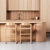 Oak Bar Stool Carl – Oak – Wood Seat in a modern kitchen with a sculpted wooden frame.