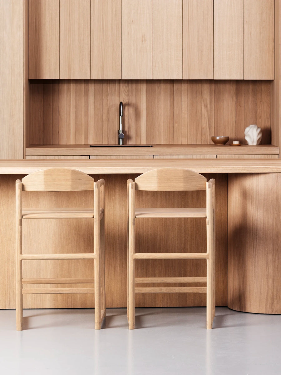Oak Bar Stool Carl – Oak – Wood Seat in a modern kitchen with a sculpted wooden frame.