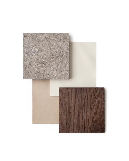 Material board featuring a dark oak wood sample, speckled dekton stone slab, and neutral beige and cream fabric swatches arranged in a minimalist Scandinavian palette.
