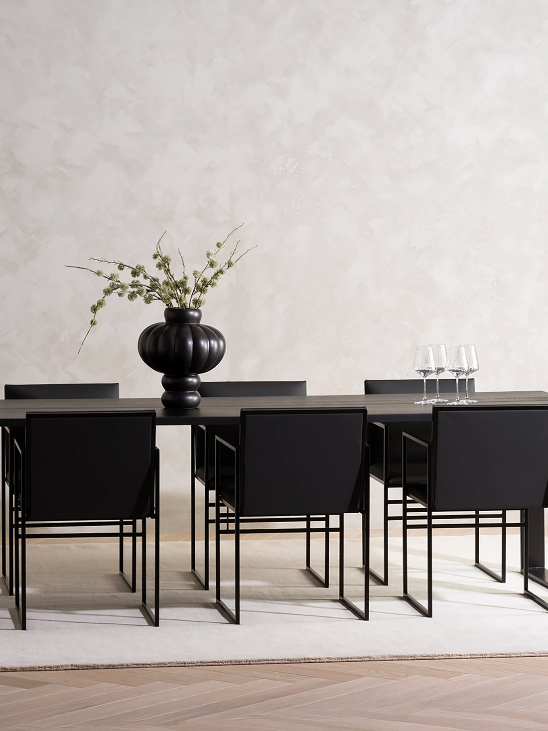 Dining Table Diana in black stained oak seating eight, with black Sella dining chairs on a pale rug