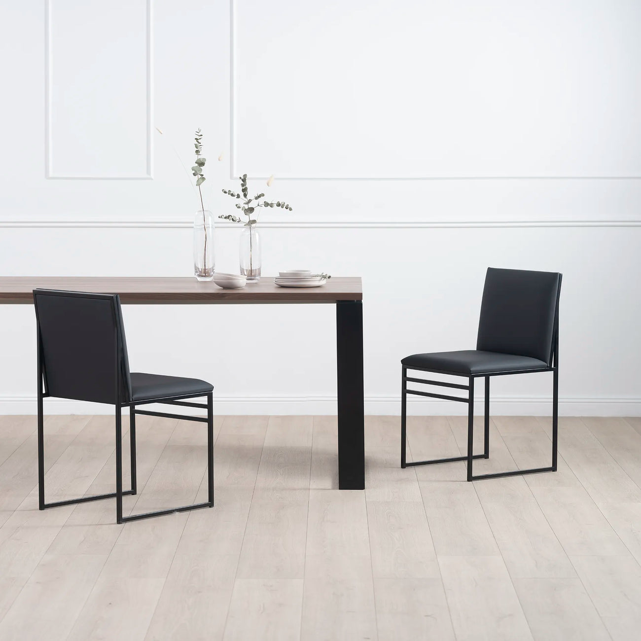 Diana dining table in black with dark oak, paired with modern black chairs, creating a minimalist dining space.