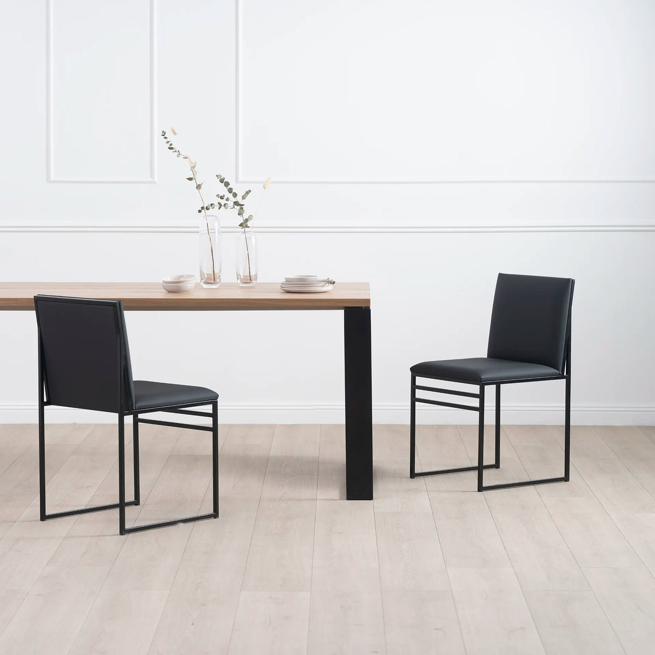 Diana dining table in black with oak featuring two stylish black chairs, perfect for a Scandinavian-inspired dining setup.
