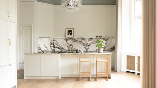 Ebba bar stools in a Danish design kitchen inside a Copenhagen apartment with marble backsplash, soft natural light, and Scandinavian interior details.