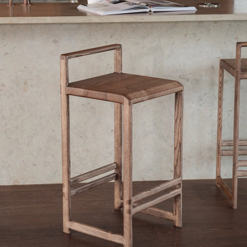 Ebba Bar stool in dark oak, showcasing its modern silhouette and sculptural design for contemporary spaces.