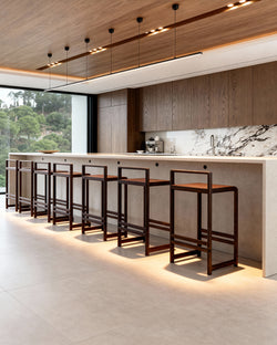 This image shows 10 Ebba barstools from by Crea in dark stained oak in a Dark oak minimalistic kitchen with contemporary light stone marble top. 