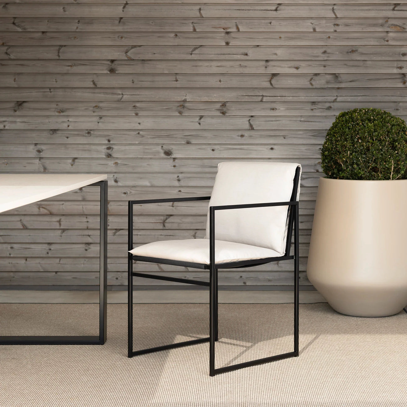 Elsy outdoor chair in black frame with marble acrylic, enhancing contemporary outdoor spaces with sleek design.