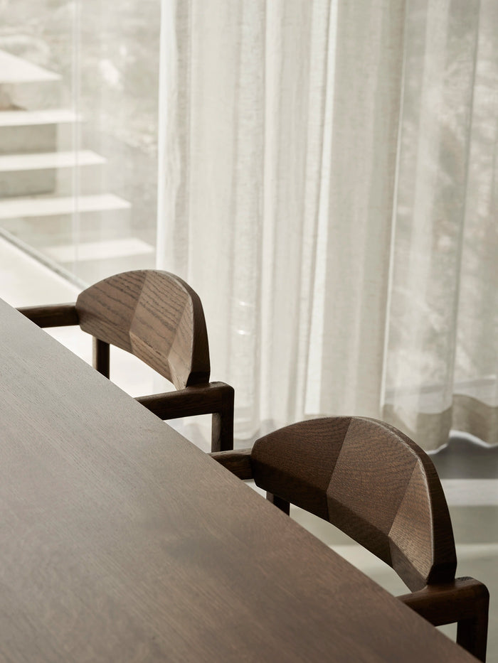 Detailed view of solid oak dining chair backs with refined craftsmanship in a soft Scandinavian interior setting.