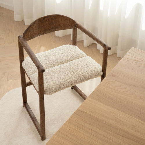 Erik dining chair in dark oak with ivory bouclé upholstery, showcasing a stylish modern design.