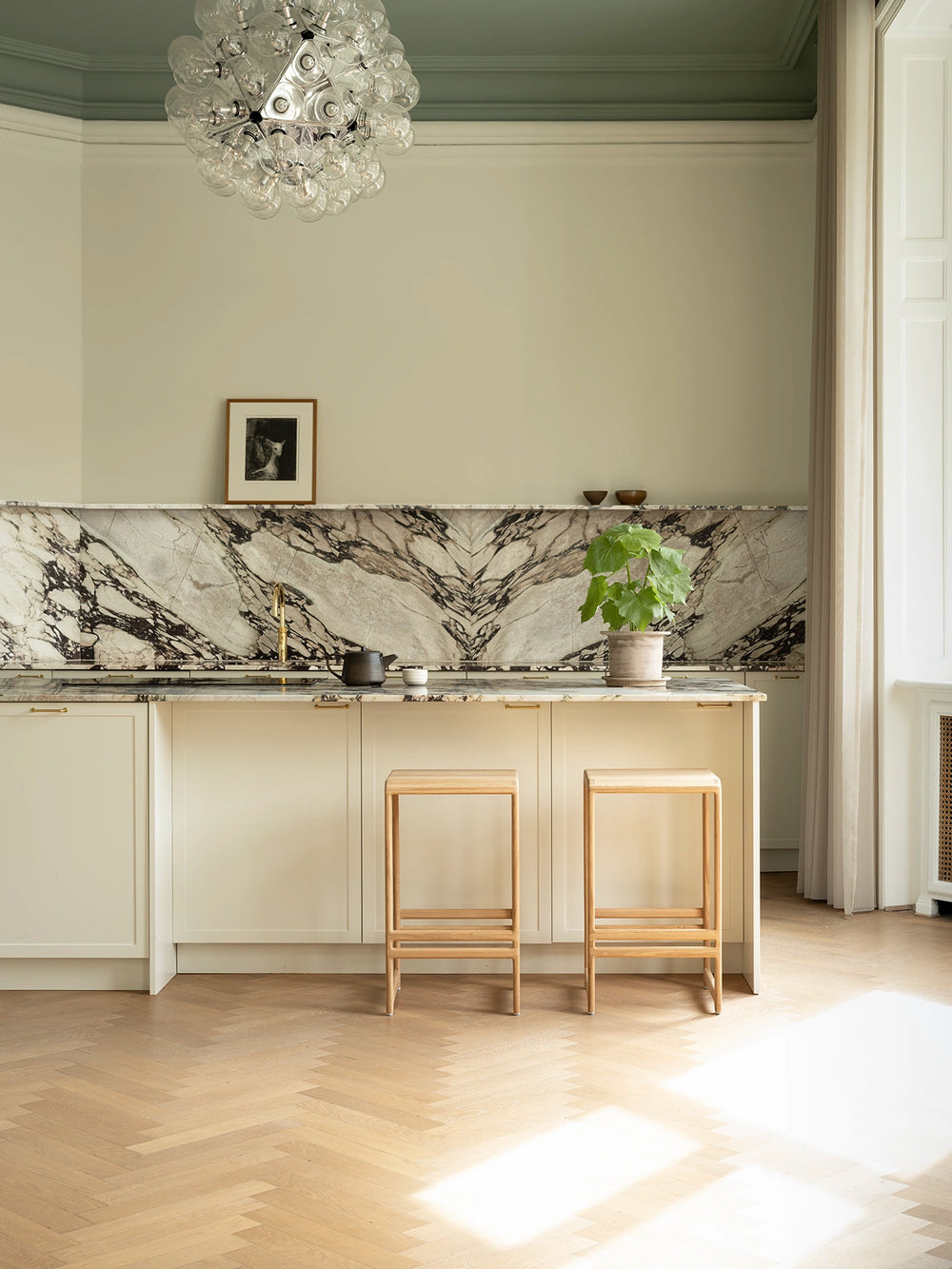 Solid oak bar stools placed in a refined Danish design kitchen with Scandinavian materials and minimalist styling.