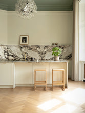 Solid oak bar stools placed in a refined Danish design kitchen with Scandinavian materials and minimalist styling.