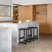 Stylish Eva bar stools in black oak featured in a modern kitchen with a marble island and wooden cabinetry.