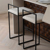 Freja bar stools with black frame and ivory bouclé cushions, stylish low backrest for comfort at the kitchen counter.