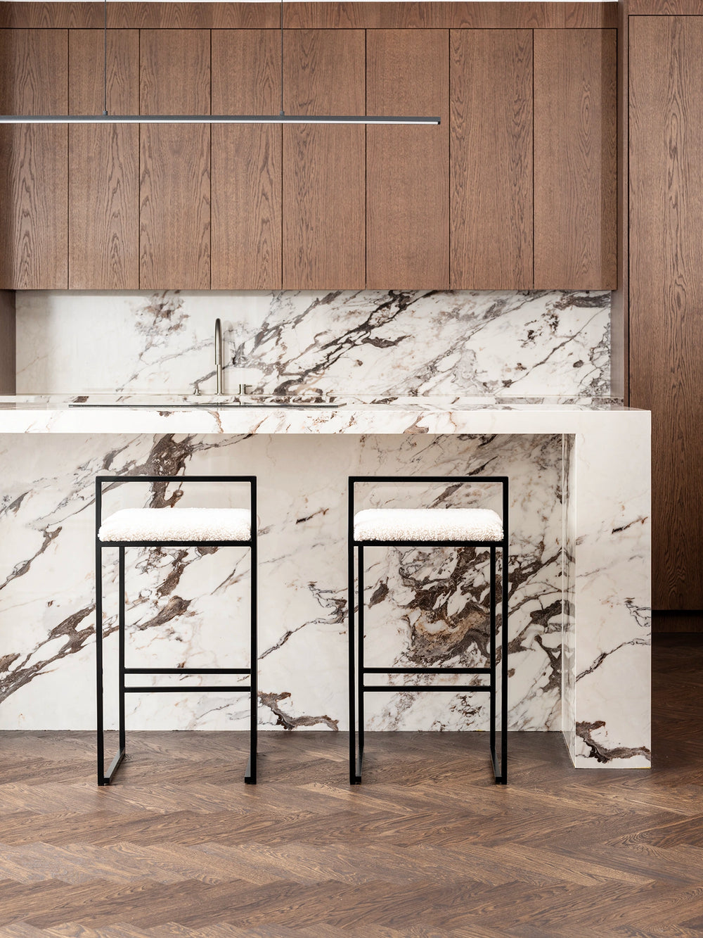 Breakfast Bar Stool Freja with black frame and ivory bouclé cushion in modern kitchen setting.