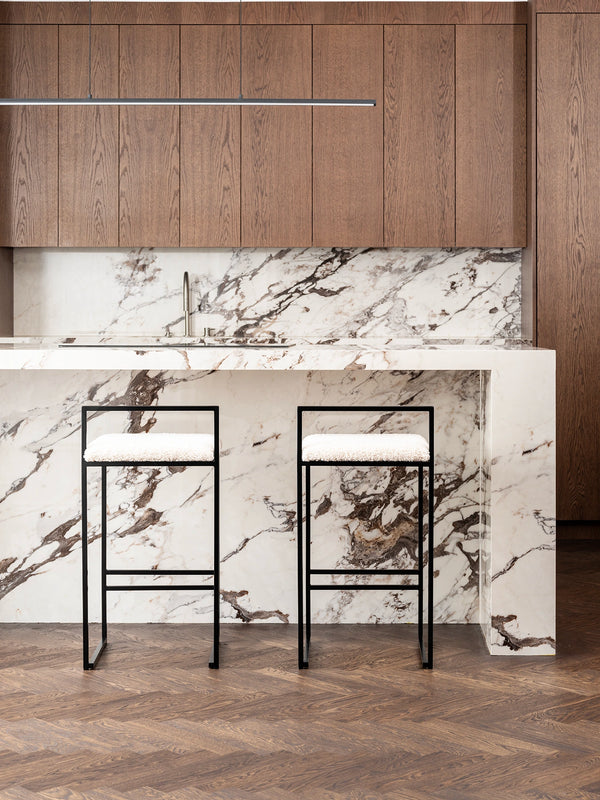 Breakfast Bar Stool Freja with black frame and ivory bouclé cushion in modern kitchen setting.
