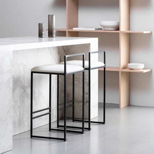 Freja bar stools in black steel with ivory leather cushions, perfect for modern kitchen and bar settings.