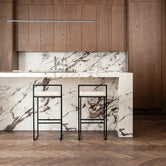 Bar Chair Freja with black frame and ivory leather cushion at a modern kitchen island with marble countertop.