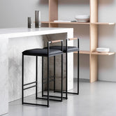 Bar Stool Freja with black frame and leather cushion in modern kitchen setting.