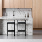 Kitchen Bar Stool Freja with black frame and leather cushion in modern kitchen setting.