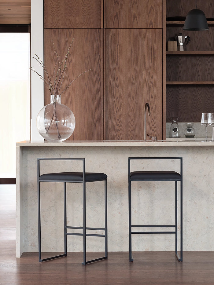 Bar Stool Freja with black frame and jade black leather cushion in a modern kitchen setting.