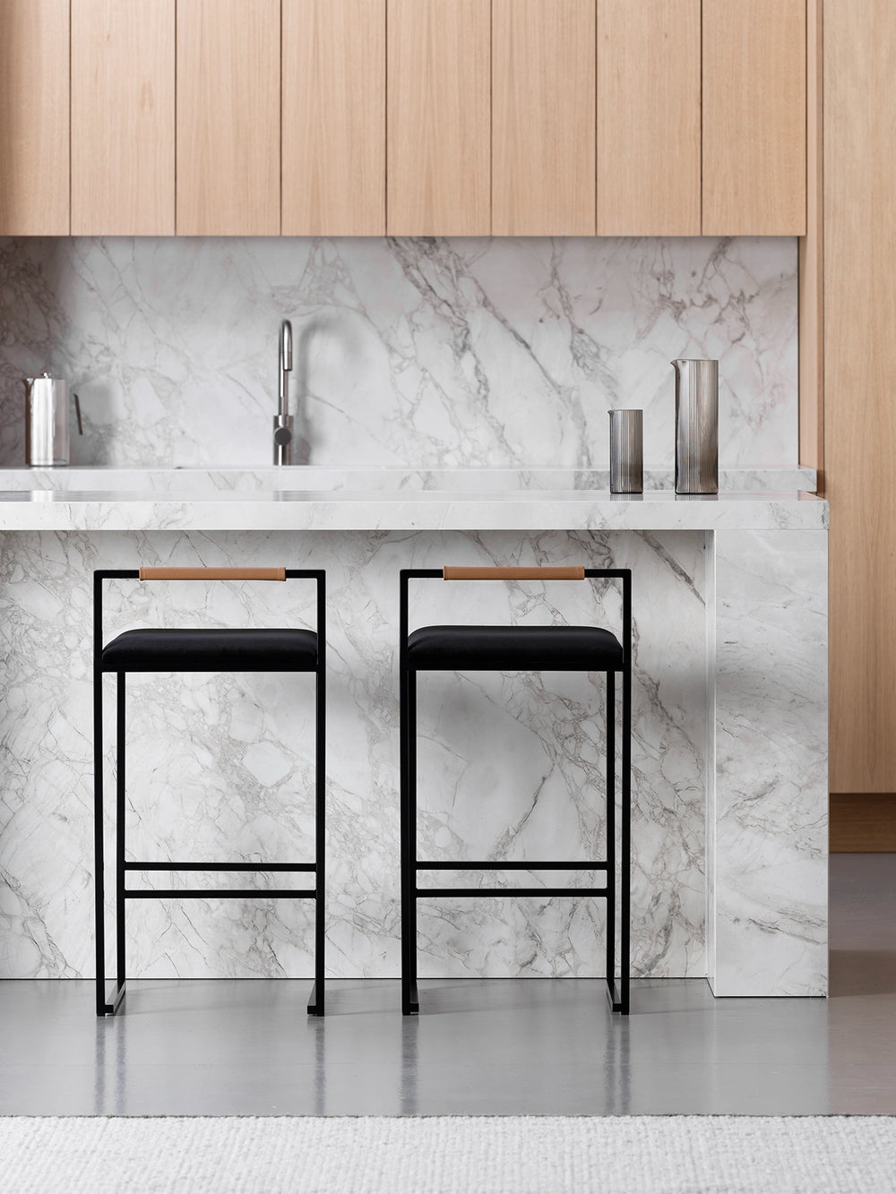 Bar Stool Freja with black frame and velvet cushion at a modern kitchen island.
