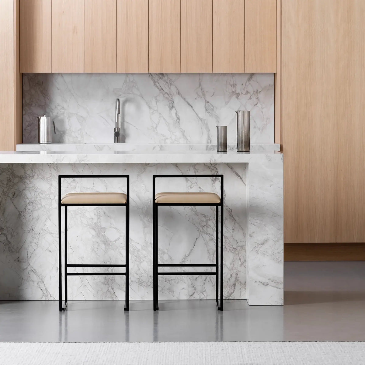 Freja bar stool in black steel with latte leather seat, perfect for modern kitchen islands and bar counters.