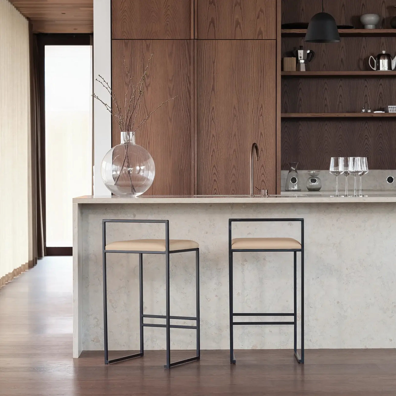 Freja bar stools with black steel frame and latte leather seats in modern kitchen setting.