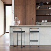 Bar Stool Freja with black frame and leather cushion in a modern kitchen setting.