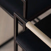 Close-up of Freja bar stool armrest featuring black frame and latte leather grip for modern interiors.