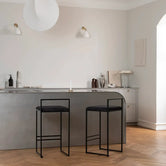 Bar Stool Freja with black frame and jade black velvet cushion in modern kitchen setting.