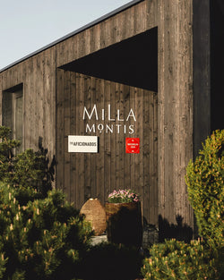 Entrance to Hotel Milla Montis in South Tyrol. A entrance in dark wood-paneled building exterior with large white 