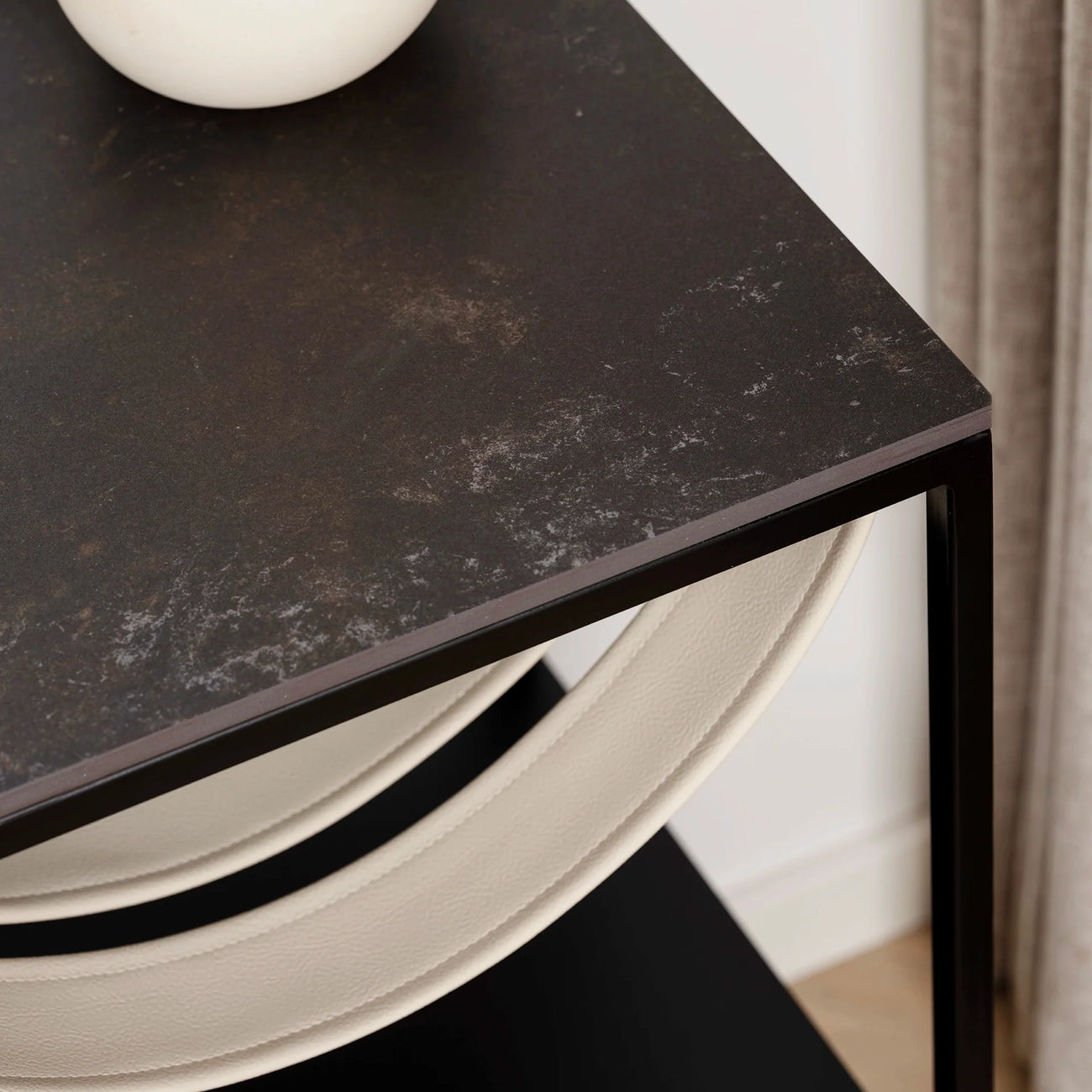Close-up of the Iris bed table black frame with Kelya dekton top and stylish decorative vase.