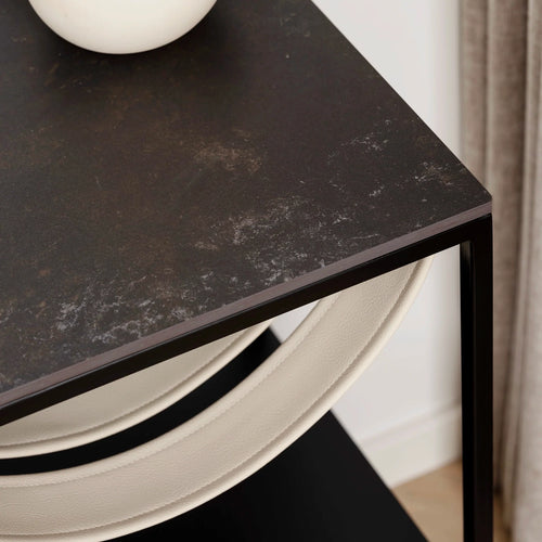 Close-up of the Iris bed table black frame with Kelya dekton top and stylish decorative vase.
