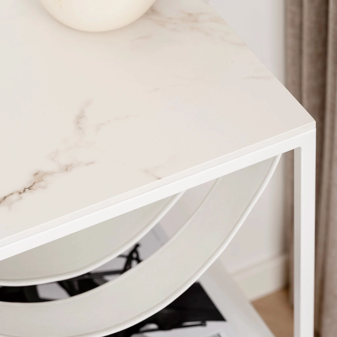 Close-up of the Iris bed table with a white frame and Entzo dekton top, featuring a sleek marble-like design.