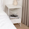 Iris bed table in white leather with sleek design, featuring a minimalistic tabletop and modern bedside storage.