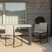 Minimalist Isa outdoor chairs in black frame with light cushions, paired with a stylish outdoor table on a patio.