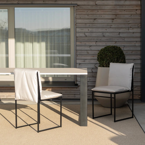 Isa outdoor chair in black marble acrylic style, paired with a modern table, enhancing Scandinavian outdoor living.