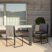 Isa outdoor chair in black onyx acrylic, elegantly placed beside a modern dining table on a stylish patio.
