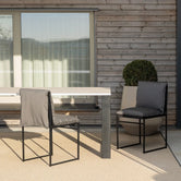 Outdoor chair Isa with black frame and onyx acrylic cushion in modern outdoor setting.