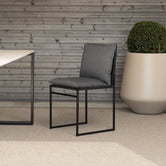 Outdoor chair Isa with black frame and onyx acrylic cushion in a contemporary outdoor setting.