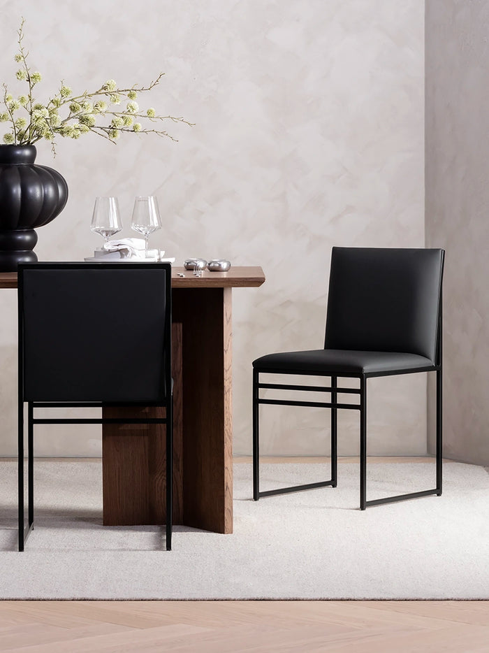 Dining chair Isabell with black leather cushion and black frame in modern dining setting.