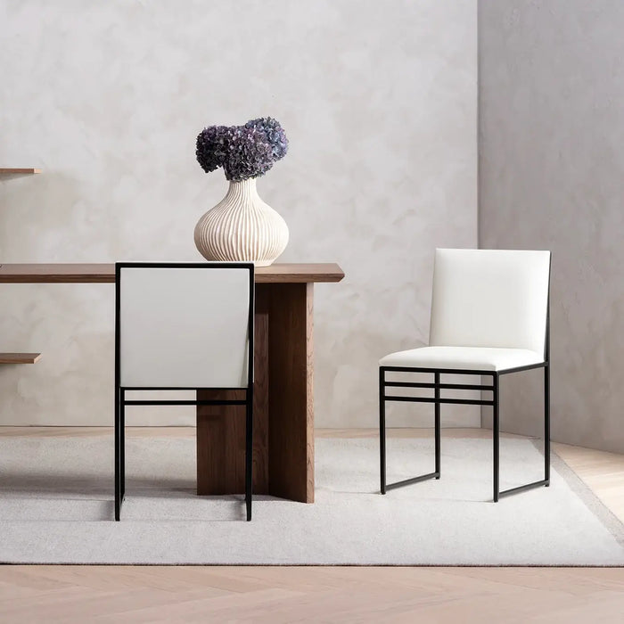 Dining chair Isabell with black frame and ivory leather cushion in a modern dining setting.